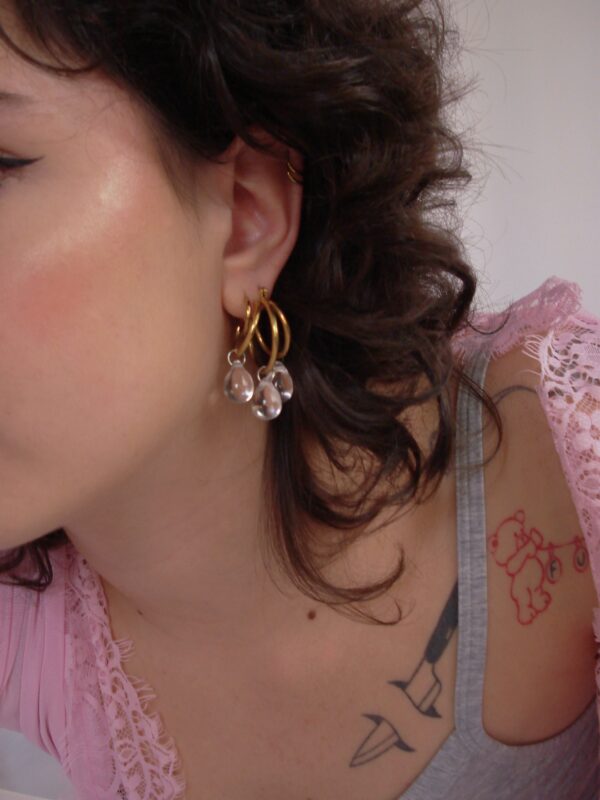 Mono boucle d’oreilles en acier inoxydable composée d'une créole doré, et de perles en verre tchèque transparentes