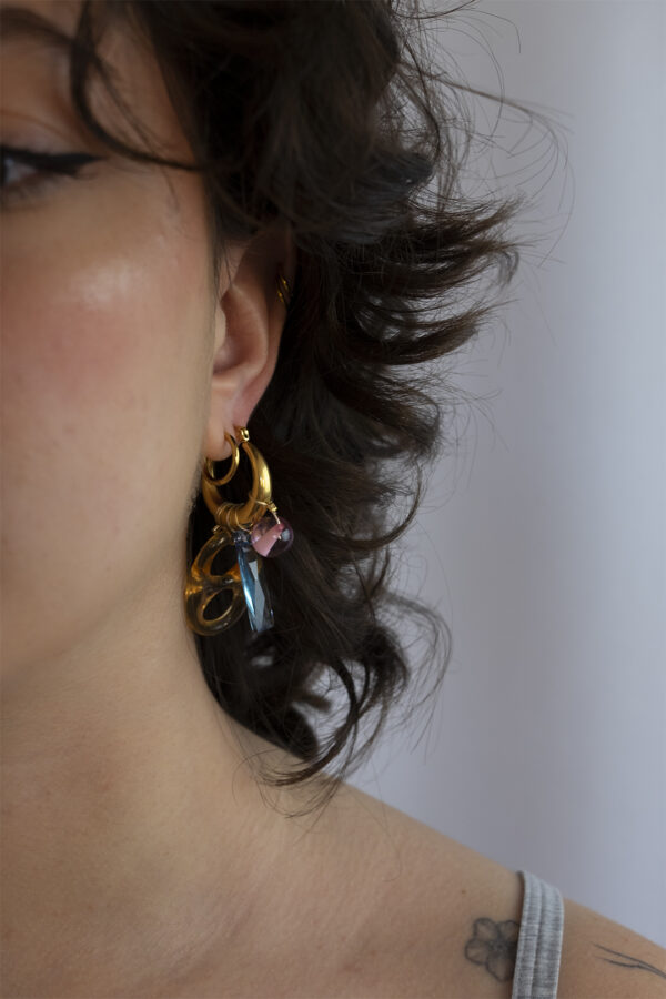 Mono boucle d’oreilles en acier inoxydable composée d’une créole doré, de perles synthétiques et d'un pendentif en cristal bleu
