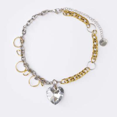 Il s'agit d'un collier composé d'une chaine doré et argenté entrelaissés de plusieurs anneaux, avec un pendentif coeur en cristal