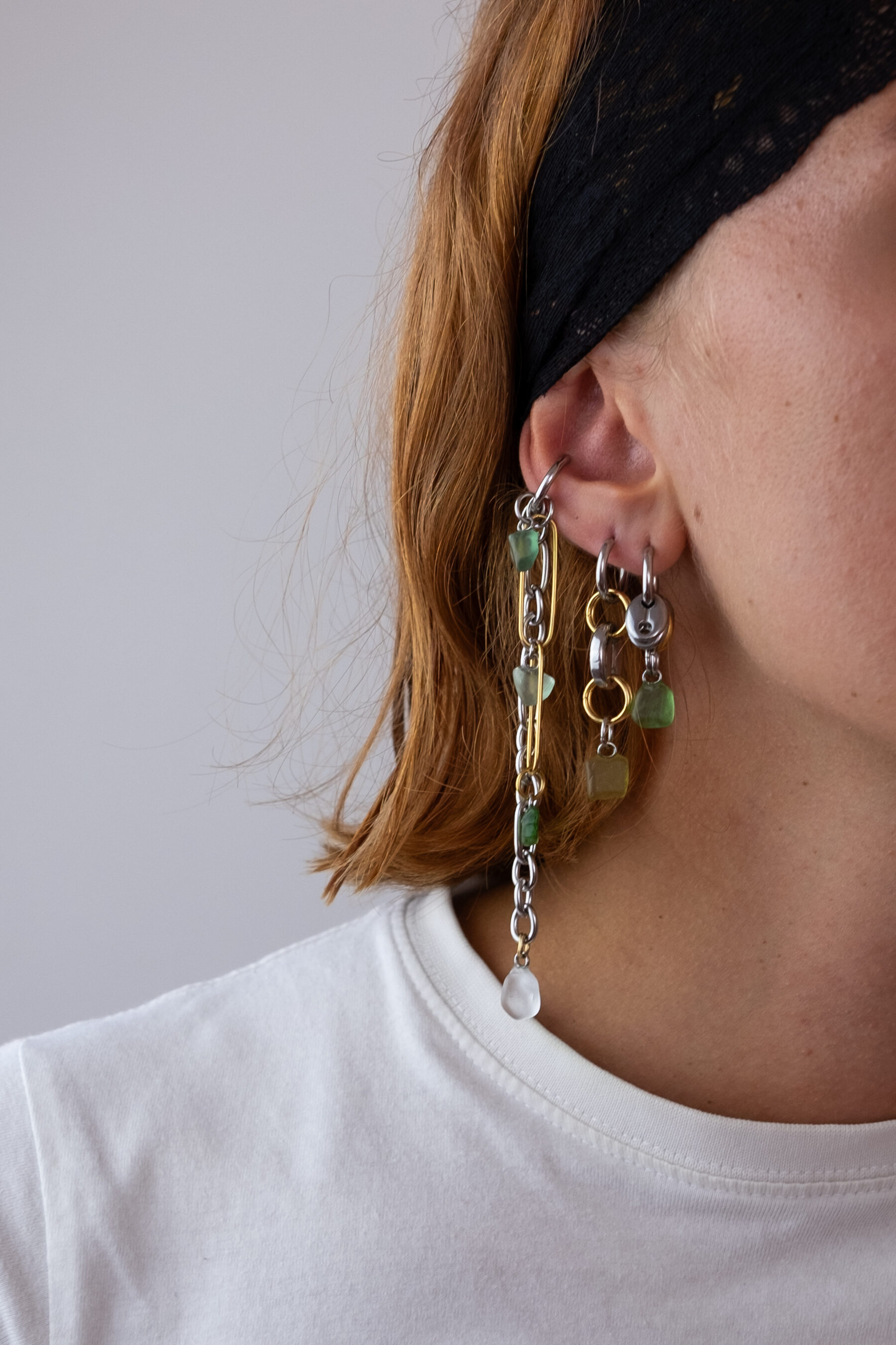 Mono boucle d’oreilles en acier inoxydable composée d’une créole doré ou argenté, et de morceaux de verre poli ramassés sur les plages du sud de la France disposés sur des apprêts dorés et argentés