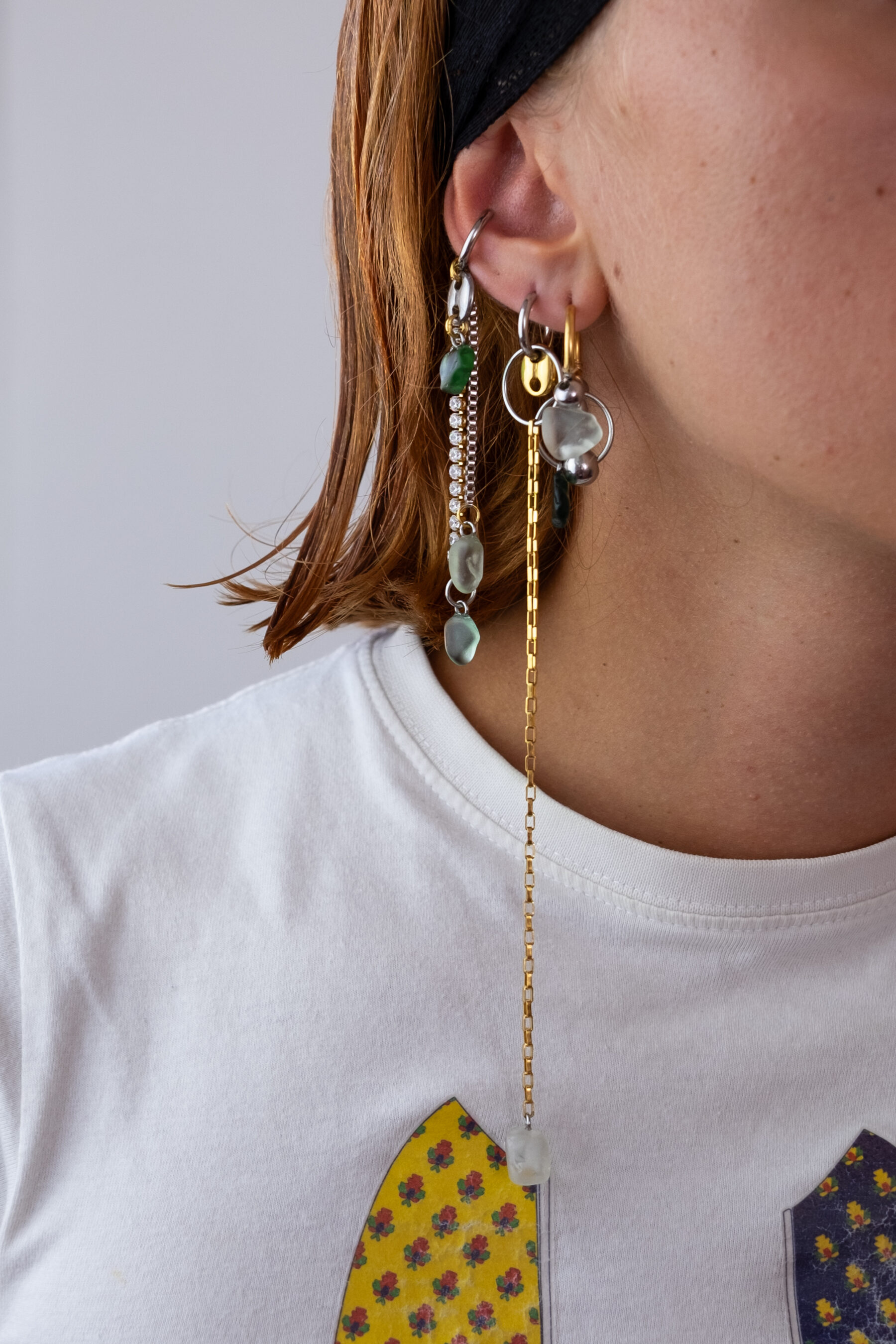 Mono boucle d’oreilles en acier inoxydable composée d’une créole doré ou argenté, et de morceaux de verre poli ramassés sur les plages du sud de la France agrémentés de chaines longues dorées ou argentées